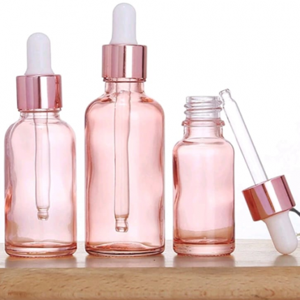 Frascos de vidrio rosa con gotero
